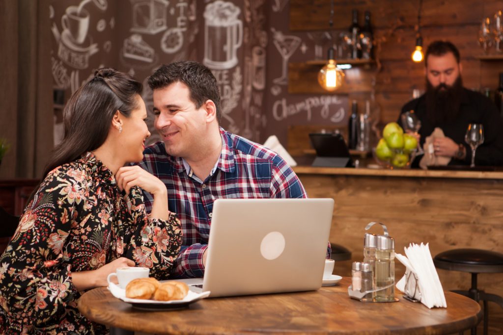 Paar in einem Café, das sich schmachtende Blicke zuwirft