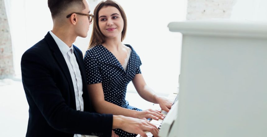 attraktives junges Paar spielt Klavier und schaut sich an